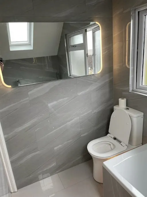 Completed bathroom renovation with grey wall tiling and modern fittings, Bexley